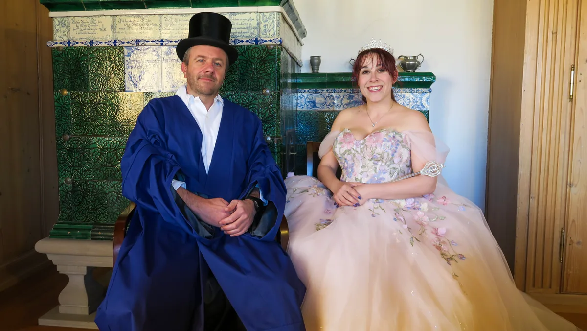 Man sieht einen Mann mit Zylinder und eine Frau mit Krönchen und Prinzessinnenkleid.